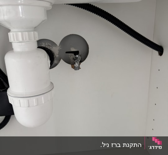 צנרת מתחת לכיור עם חיבורי מים